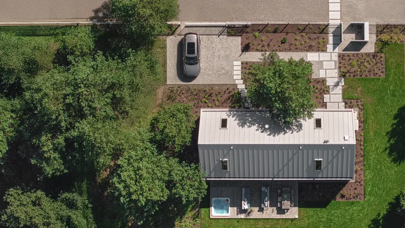 Drone view of the standing seam metal roof with skylights and surrounding planted beds