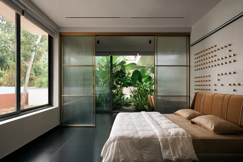 Bedroom with timber-framed translucent sliding doors opening to an interior planted courtyard