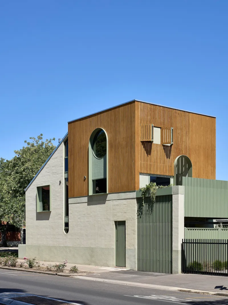 Street elevation with mixed material facade of timber cladding, pale render, and corrugated metal screening