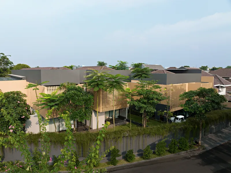 Elevated perspective of the compound showing flat roofs, lattice screens, and dense vegetation along the street