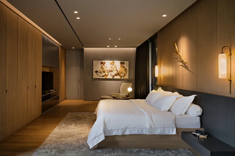 Bedroom with wood-paneled walls, floating bed, and recessed lighting in the ceiling coves