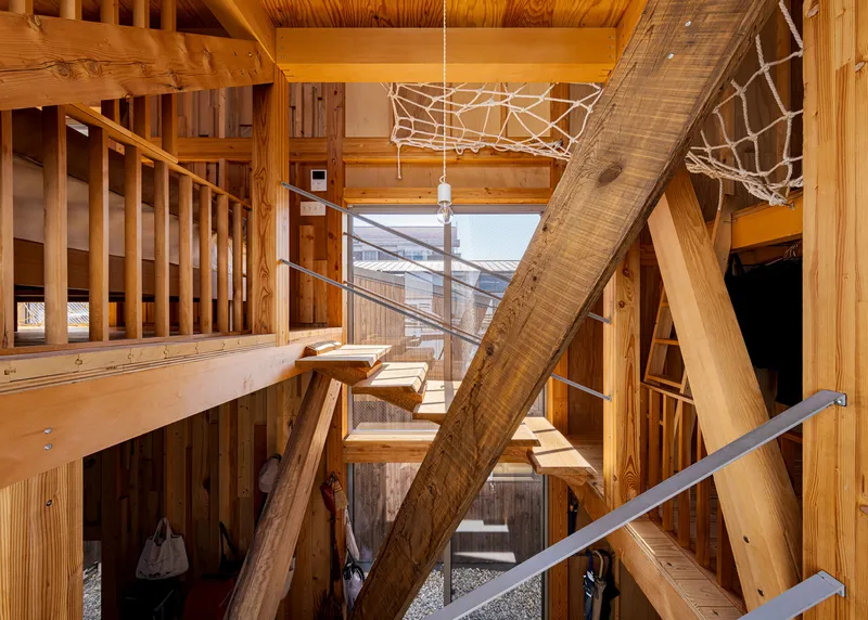Upper landing with timber bridge and rope net panels between exposed structural beams
