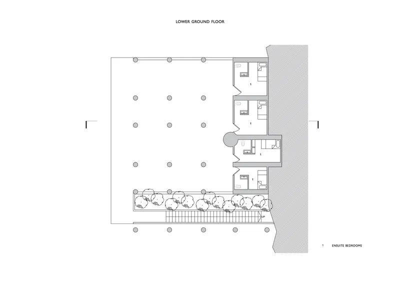 Lower ground floor plan showing open space with column grid and ensuite bedrooms along one edge