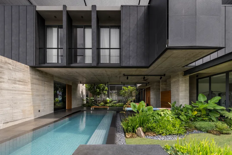 Interior courtyard with lap pool surrounded by planted beds and board-formed concrete walls