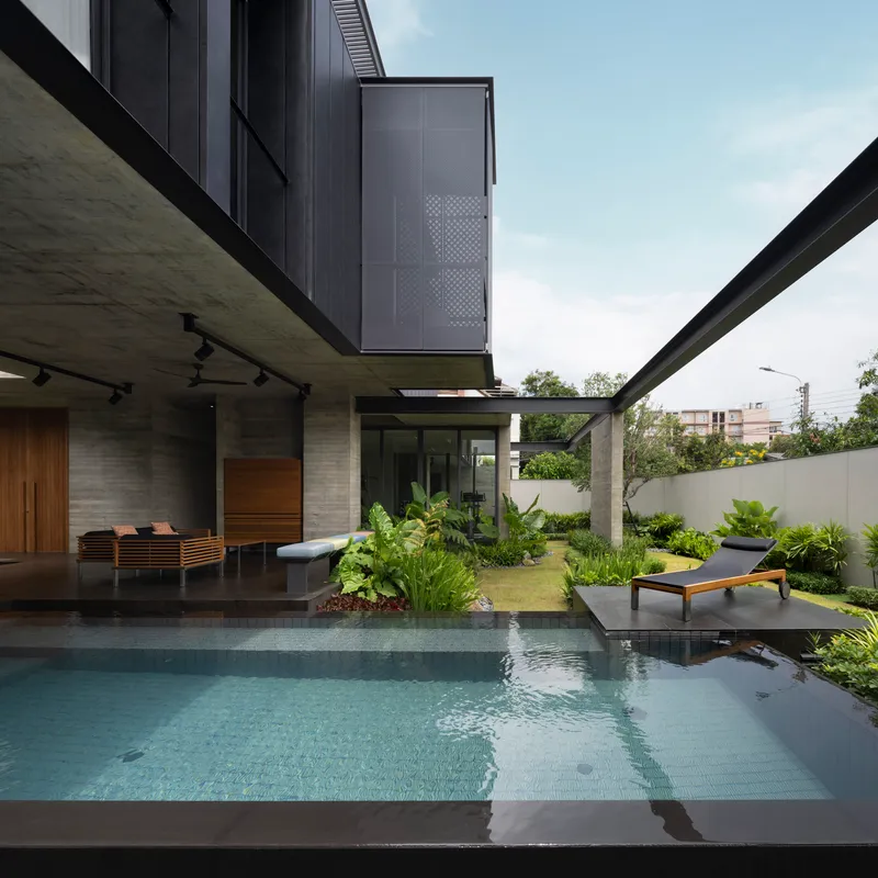 Pool deck with sunken seating area and perforated metal screen on the upper level