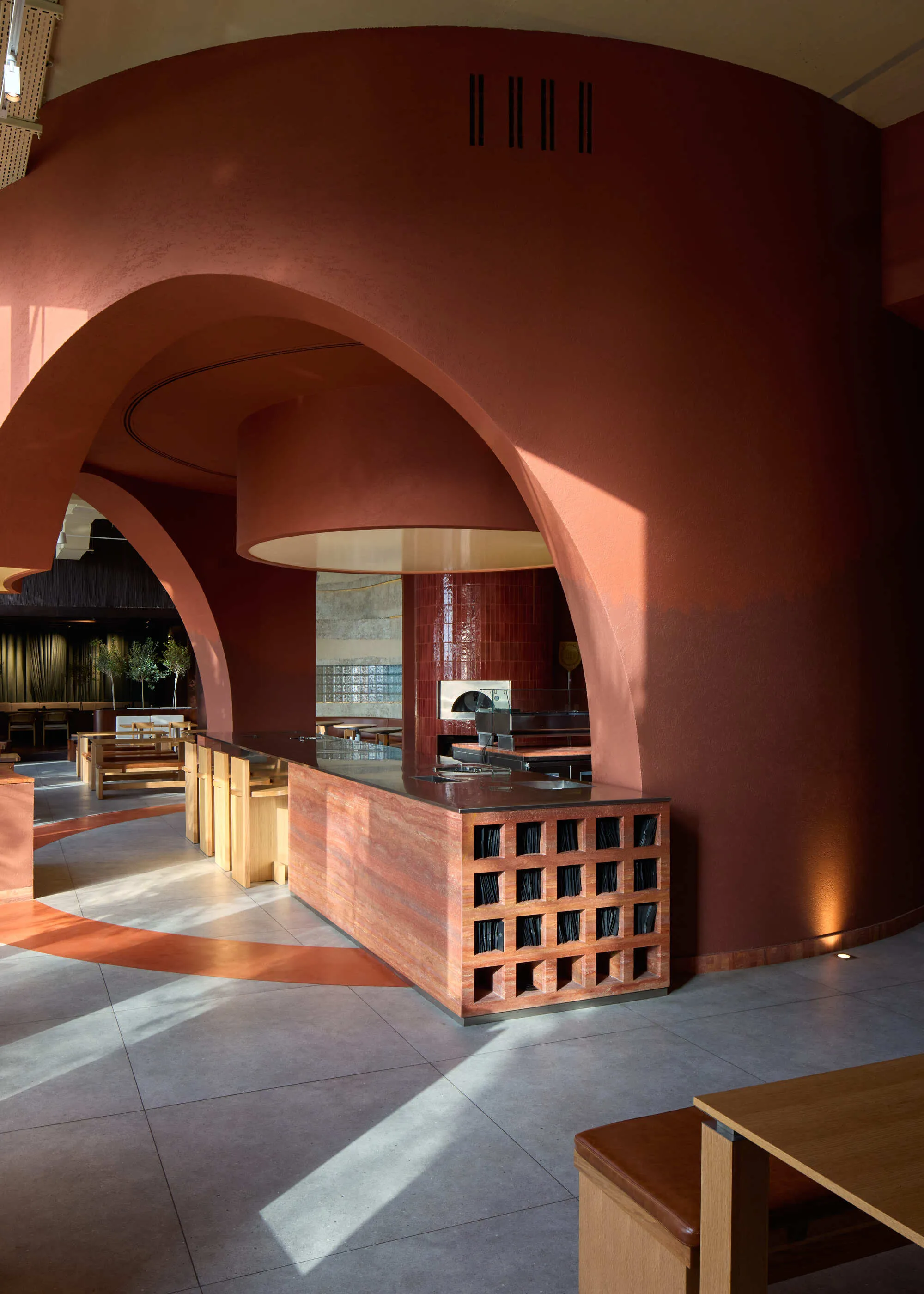 Kidz Studio Grounds a Chain Pizzeria in Abu Dhabi with Sandstone, Copper, and Botanical Geometry