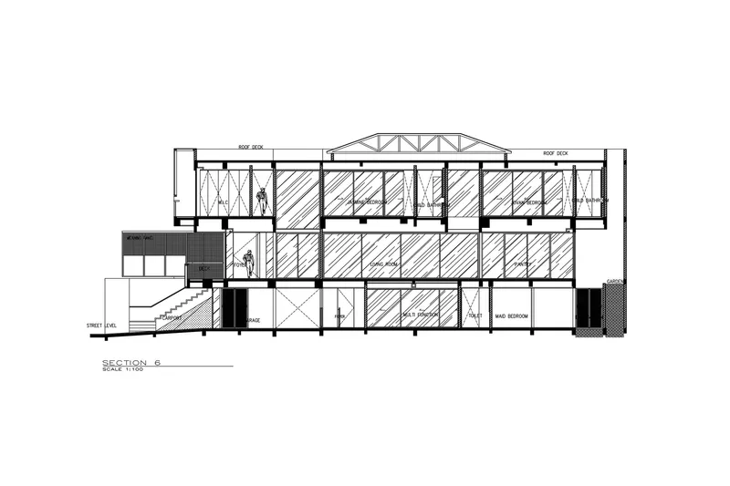 Section drawing showing the exposed truss roof spanning over three stories of bedrooms and classrooms