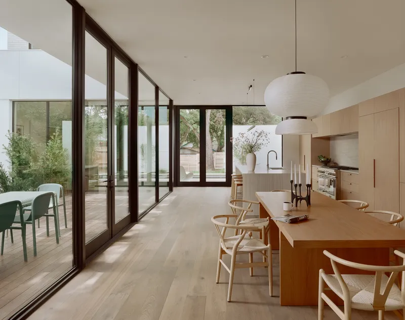 Kitchen and dining area with glazed doors opening to a planted courtyard terrace