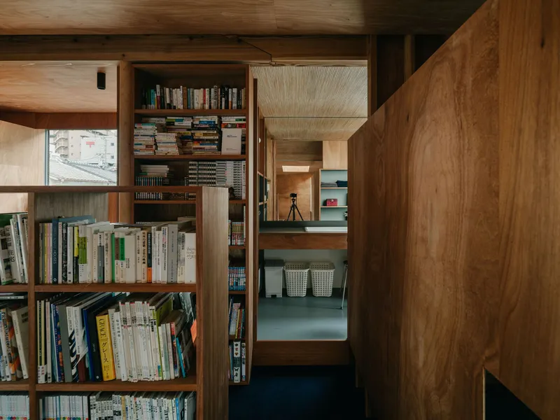 Built-in timber bookshelves framing a view through multiple rooms with varied ceiling treatments