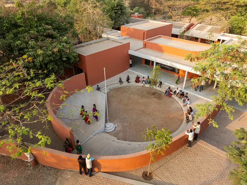Aerial view of the circular courtyard with curved walls and students gathering beneath flat roofs
