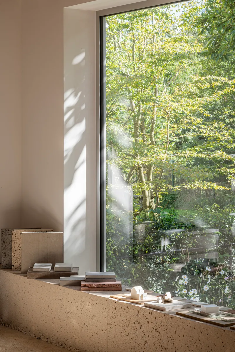 Terrazzo window sill with dappled sunlight filtering through trees outside the glazed opening