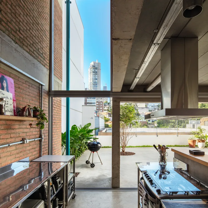 View from kitchen through glazed doors to the rear terrace with distant high-rise buildings visible