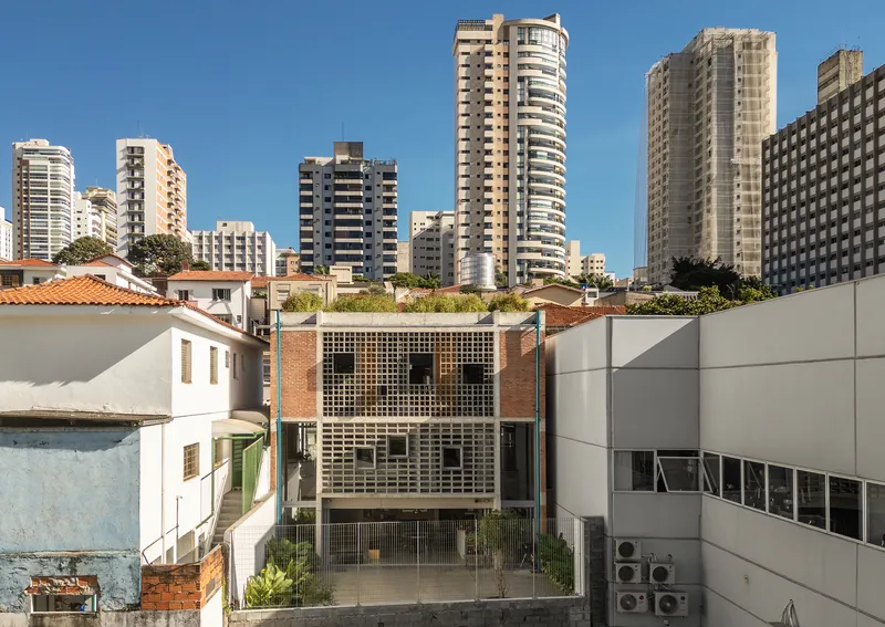 Rear elevation from neighboring rooftops showing the three-story facade with planted roof terrace