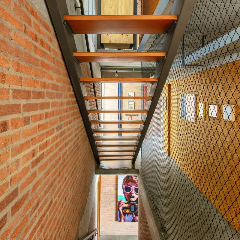 View up the open timber tread staircase with steel frame and wire mesh safety barrier