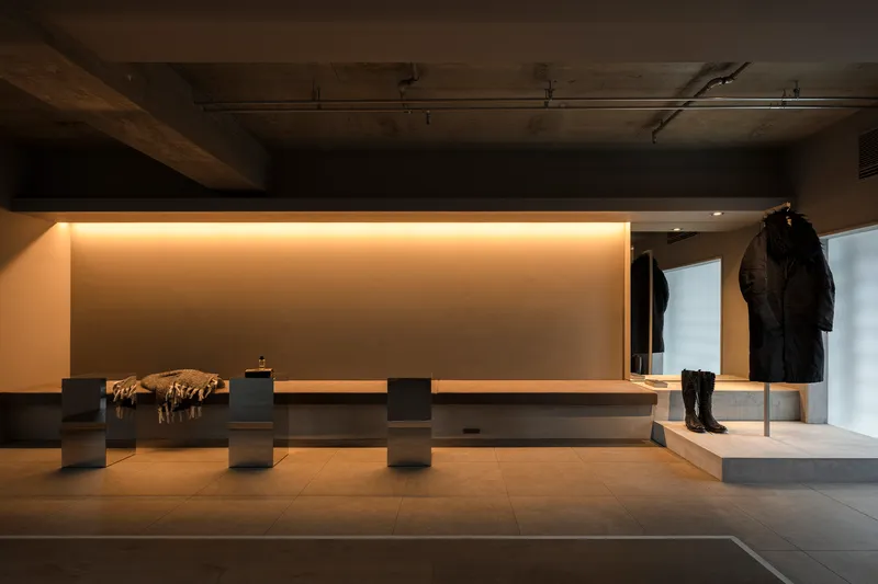 Lounge area with backlit timber bench seating and exposed concrete ceiling under warm lighting