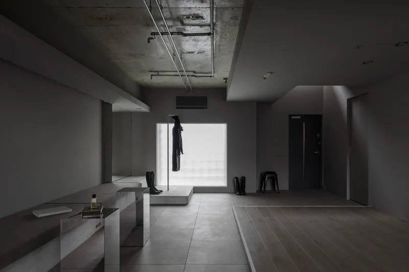 Entry foyer with exposed concrete ceiling, large window opening, and coat hanging on rack