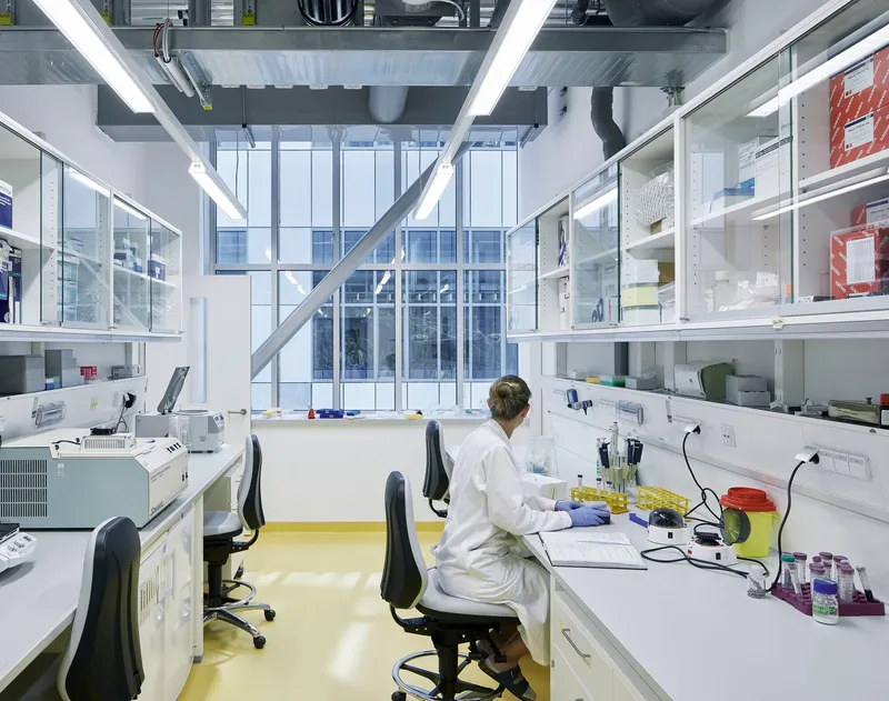Research lab with yellow resin flooring and a technician working at a white workstation