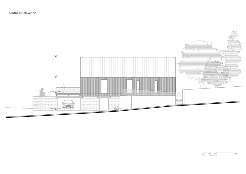 Southeast elevation drawing showing the vertical cladding and masonry base on sloping terrain