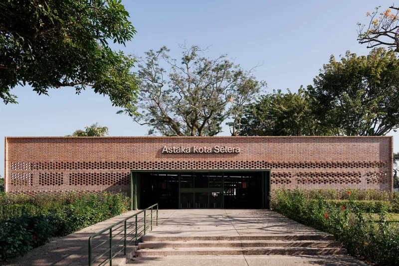 Wide entry steps leading to brick facade with perforated openings beneath signage