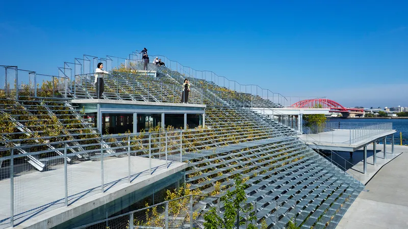 Planted terraced seating with metal grid steps and visitors standing along the upper walkway