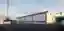 This architectural image showcases a modern industrial building with a minimalist design. The buildi