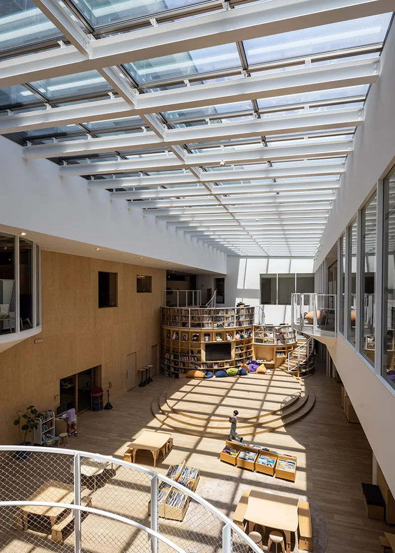 View from mezzanine showing striped sunlight pattern across timber floor and circular reading platform