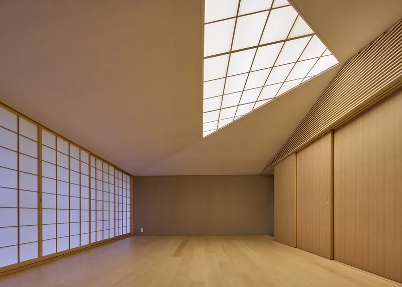 Interior room with translucent shoji screens and angular skylight casting diagonal shadows