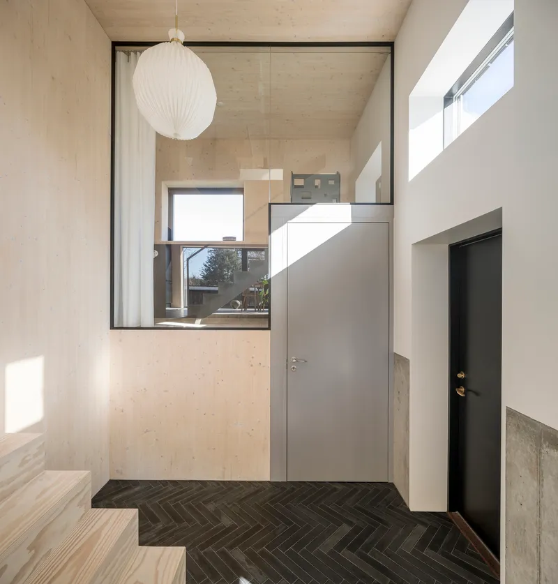 Entry hall with herringbone tile floor and grey doors beneath a spherical pendant lamp