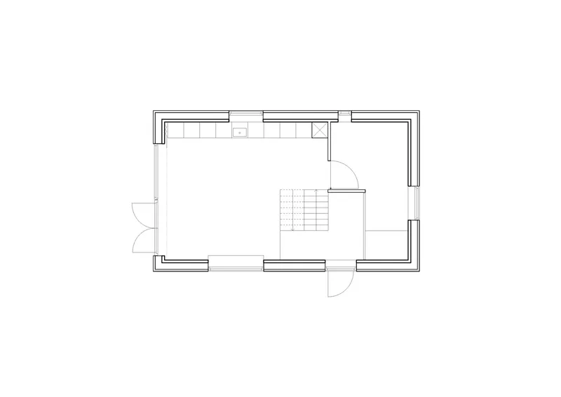 Ground floor plan drawing showing kitchen along top wall and central staircase