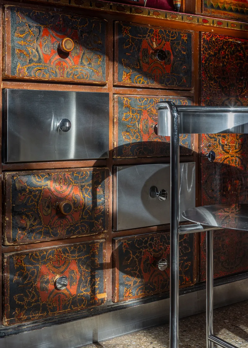 Top-down view of stainless steel basins set into ornate panels with brass hardware and patterned finishes