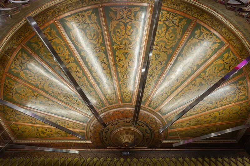 Looking up at ornate domed ceiling with painted botanical motifs radiating from central medallion