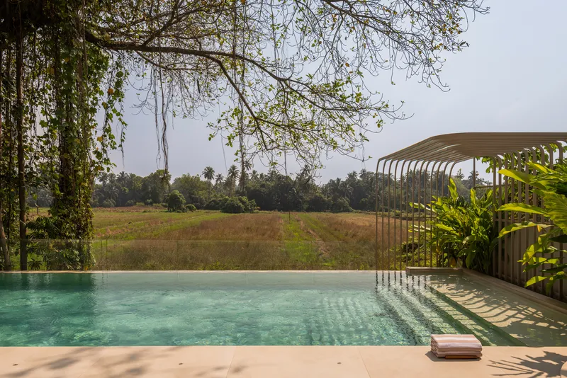 Pool deck with curved metal screen structure framing views of the agricultural landscape beyond
