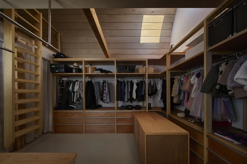 Closet interior with timber storage units and exposed wood plank ceiling with beam structure