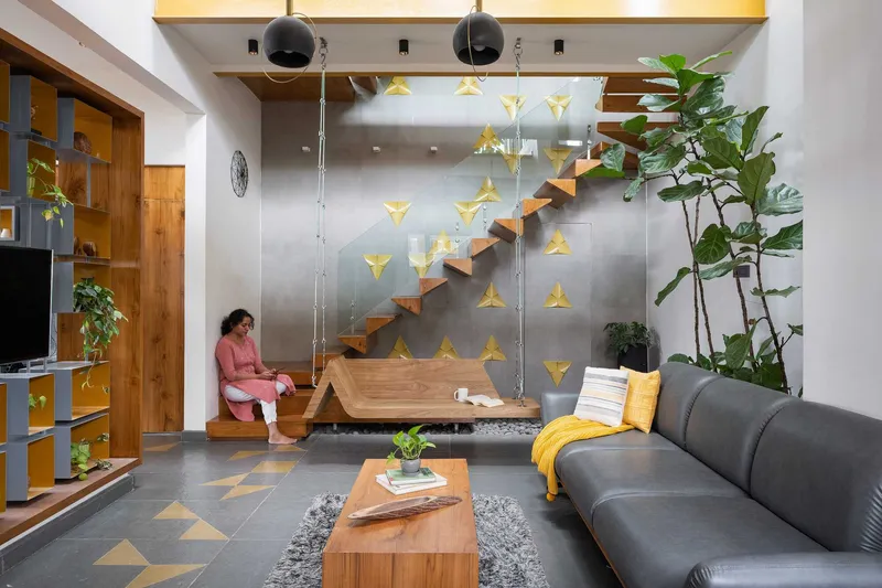 Floating timber staircase against a steel panel wall with triangular yellow floor tile accents
