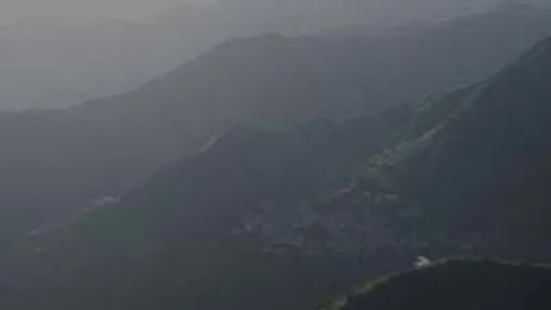 Distant view of the white-roofed structure in heavy mountain mist