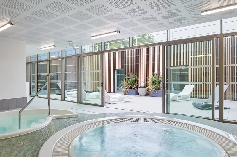 Circular spa pool with timber slatted screen and glass doors opening to an outdoor terrace