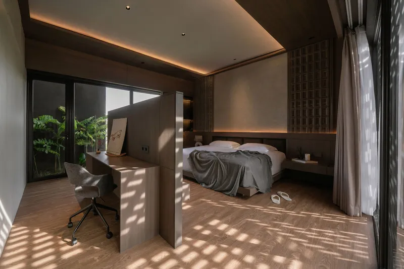 Bedroom with patterned sunlight from the screened window falling across the timber floor and bed
