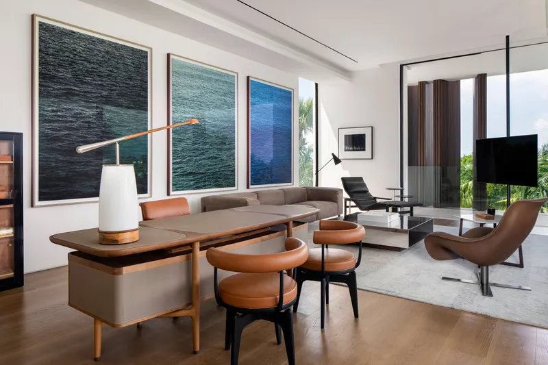 Interior lounge with triptych of water photographs above console table and seating arrangement
