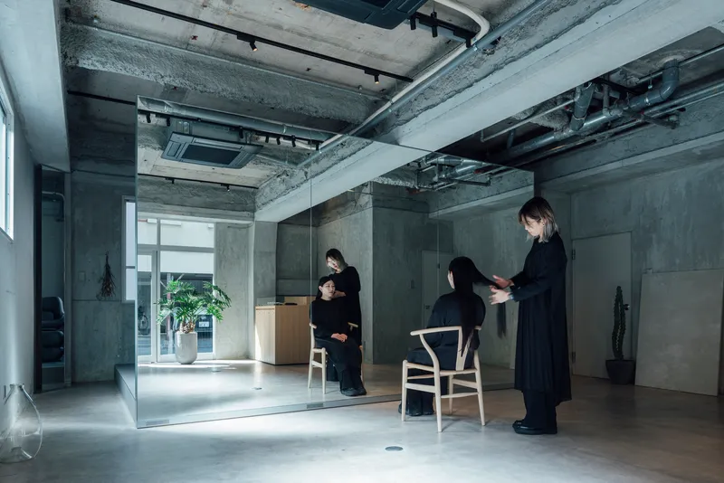 Glass partition dividing the space with three figures in black during a consultation