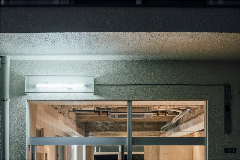 Glass doors reflecting exposed timber beams and underside of an existing upper floor structure