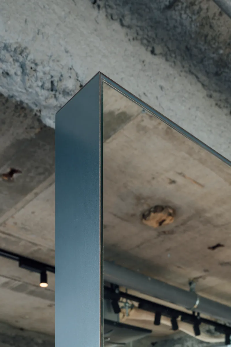 Steel column meeting the weathered concrete underside of an existing slab with visible patching