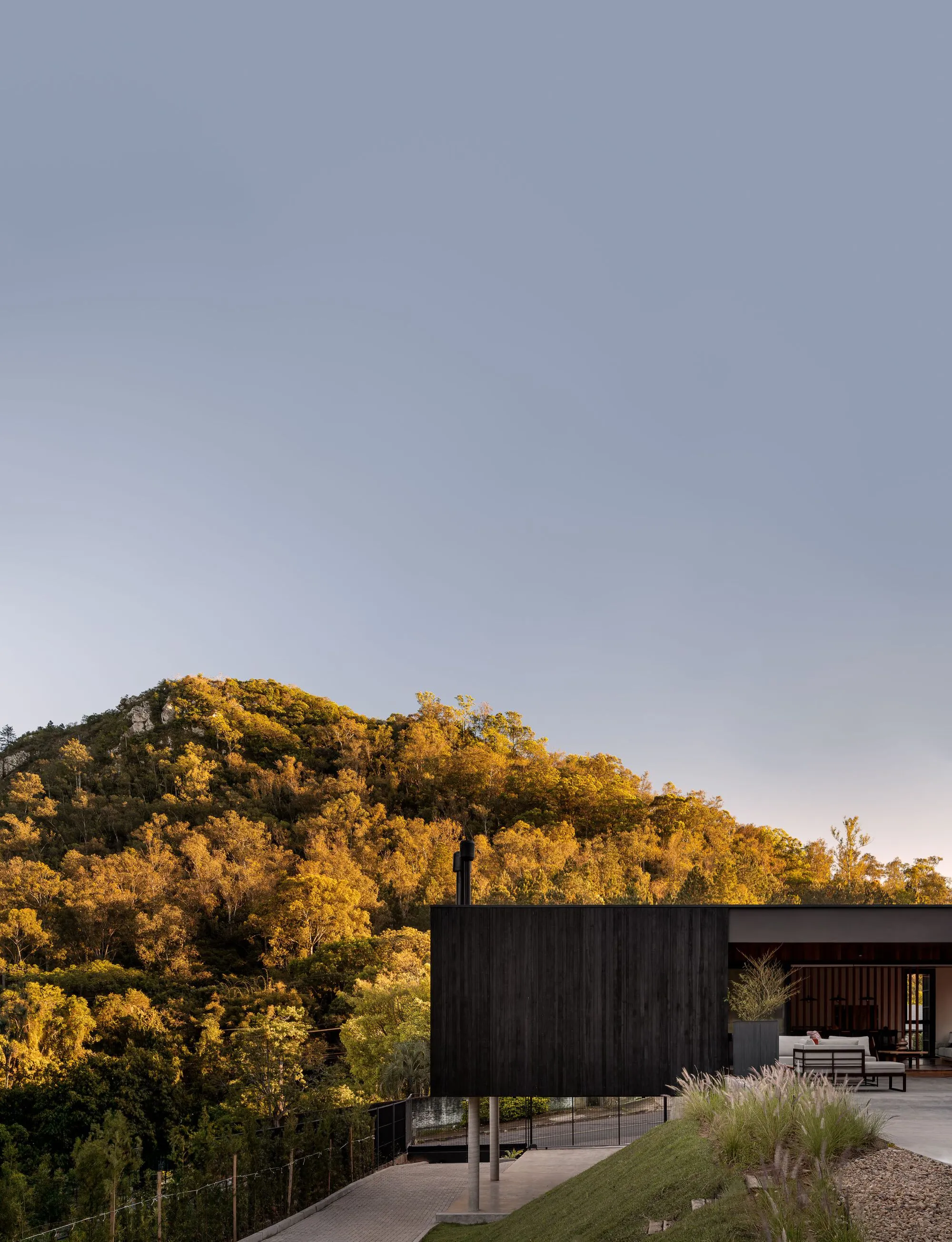 Harpa Arquitetura Nests a Charred Timber House Between Two Hills in Southern Brazil