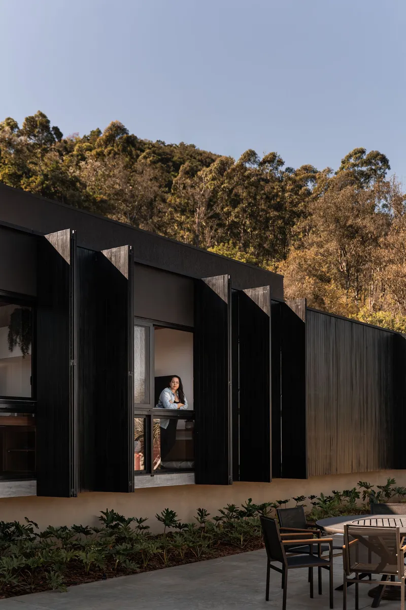 Accordion folding doors opening to a courtyard with a person framed in the threshold