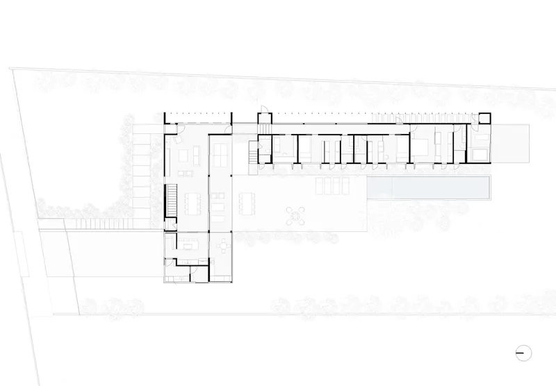 Ground floor plan drawing showing an L-shaped layout with a long linear wing and planted courtyard