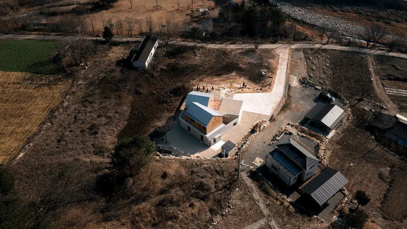 Aerial view of the compound showing the main house and two smaller outbuildings in the landscape