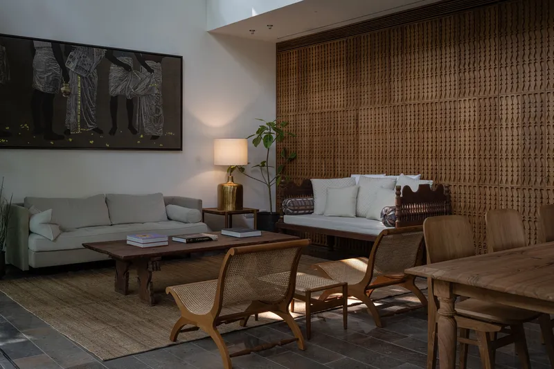Living area with woven rattan wall panel and sunlight filtering through a window