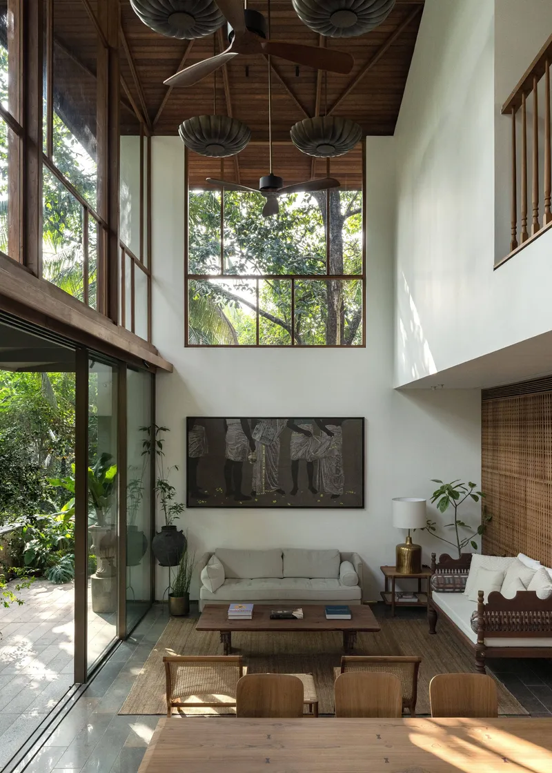 Interior view of the living room under exposed timber roof trusses and pendant lights