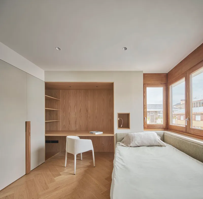 Bedroom with built-in oak desk alcove, upholstered window seat, and timber casement windows