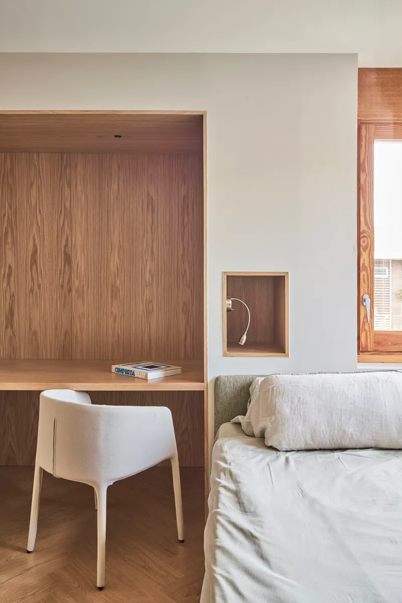 Built-in walnut desk alcove with a square display niche beside a bedroom window