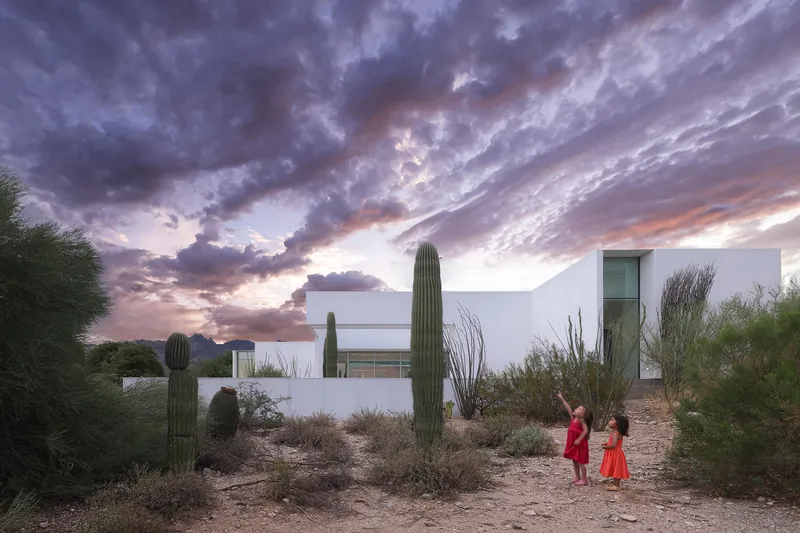 Rooftop terrace with saguaro cacti and desert vegetation at sunset with dramatic cloud formations